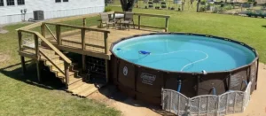 Stunning above-ground pool with a custom-built wooden deck. Ready to build your own deck? Contact us today to get started!