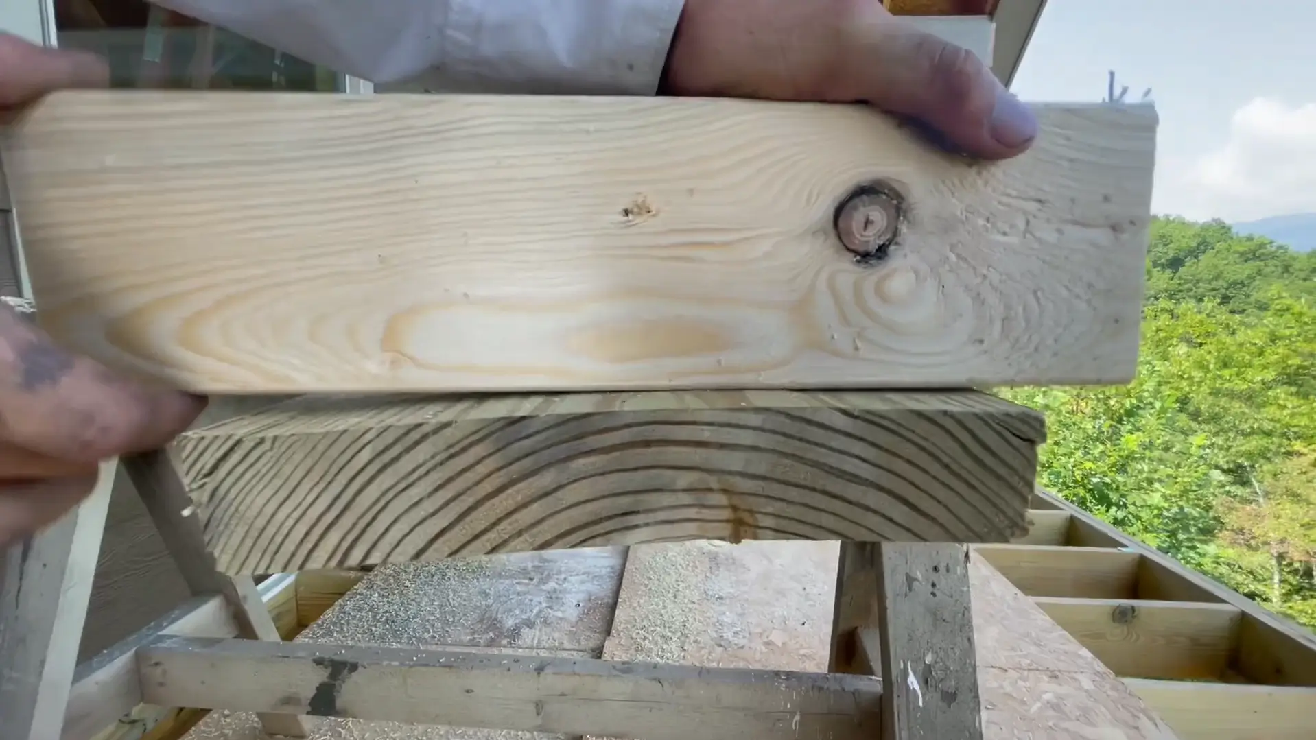 A close-up view of a contractor handling deck boards, ensuring proper drying time before installation. Hire a professional contractor to ensure your deck boards are installed correctly and last longer.