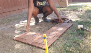 Installing deck tiles on a grass surface with precision. Hire a professional contractor to ensure your deck is installed correctly and efficiently.