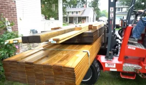 Stacked deck materials on a forklift, ready for backyard deck construction. Ensure quality and safety by hiring a professional contractor.