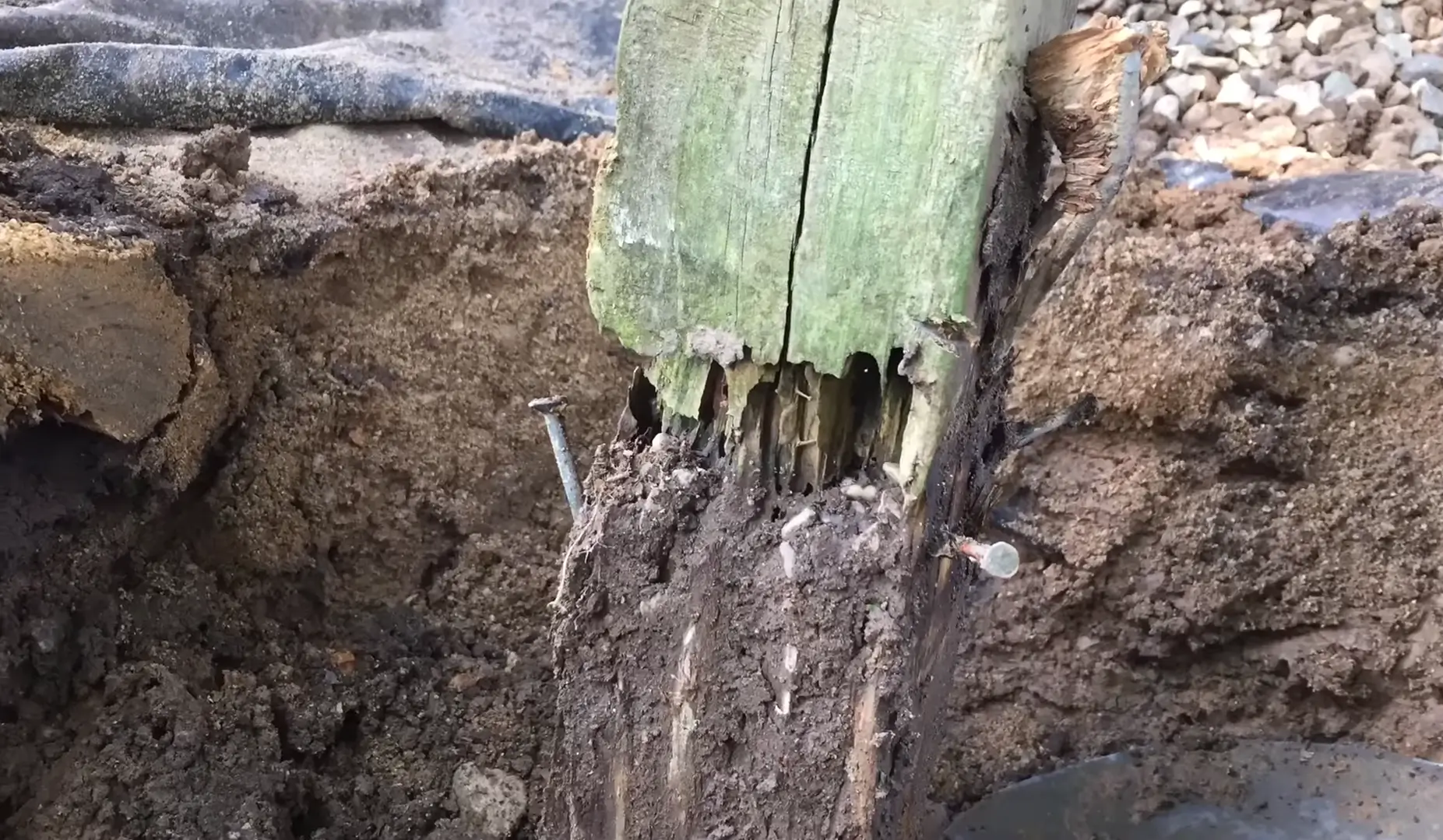 A close-up of a rotted deck post in need of repair. Contact South Shore Deck Builders for professional deck repair and restoration.